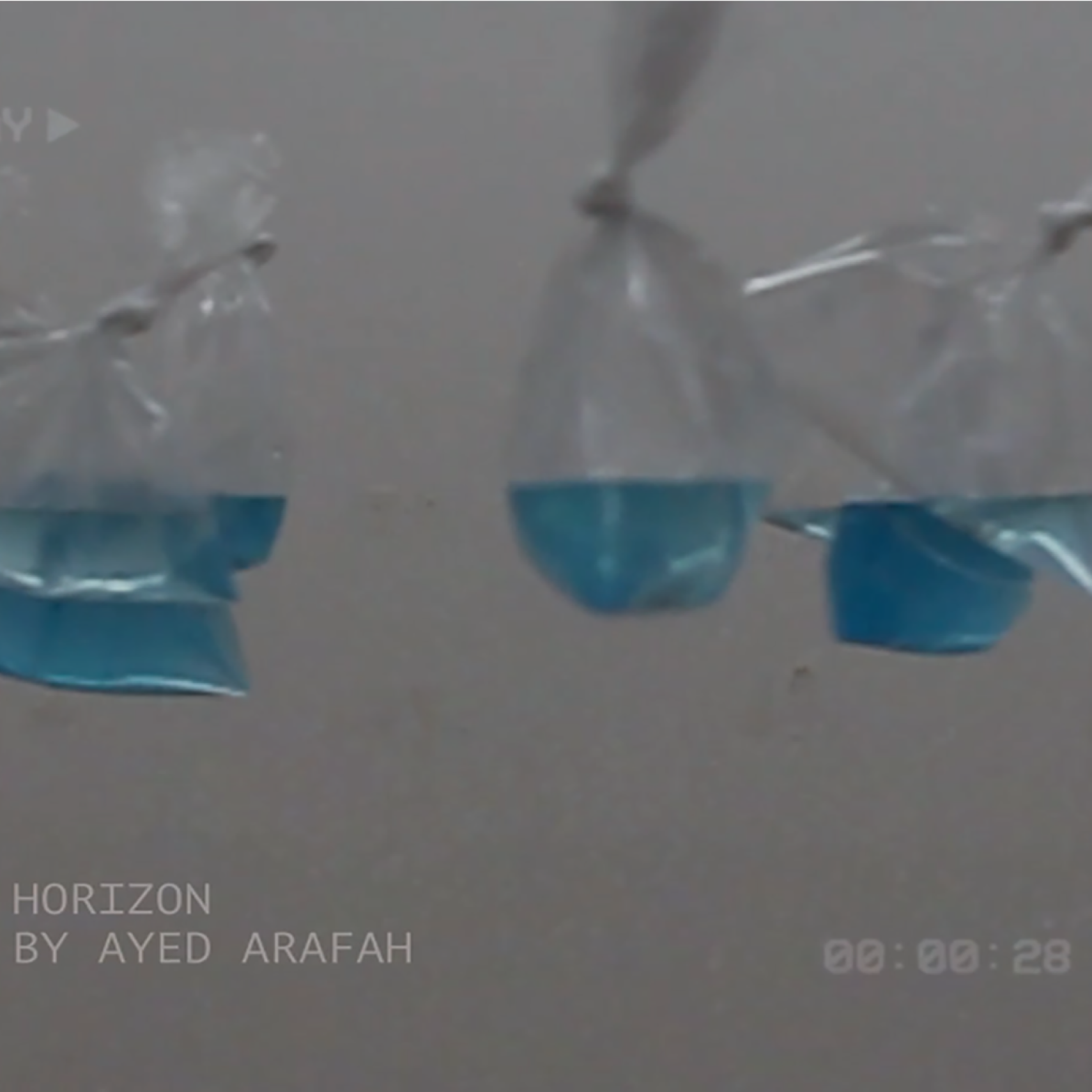 bags of blue water against a white wall