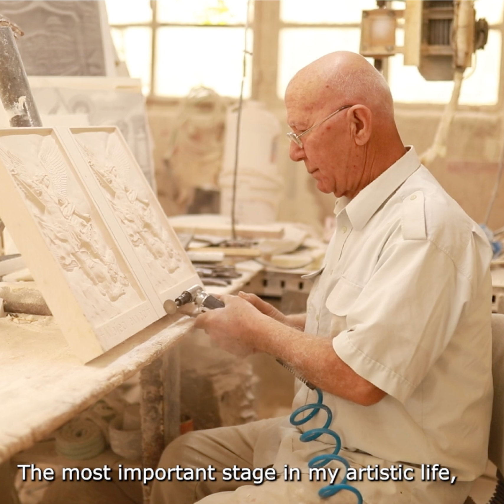 a sculptor works and the subtitles say 'the most important stage in my artistic life'